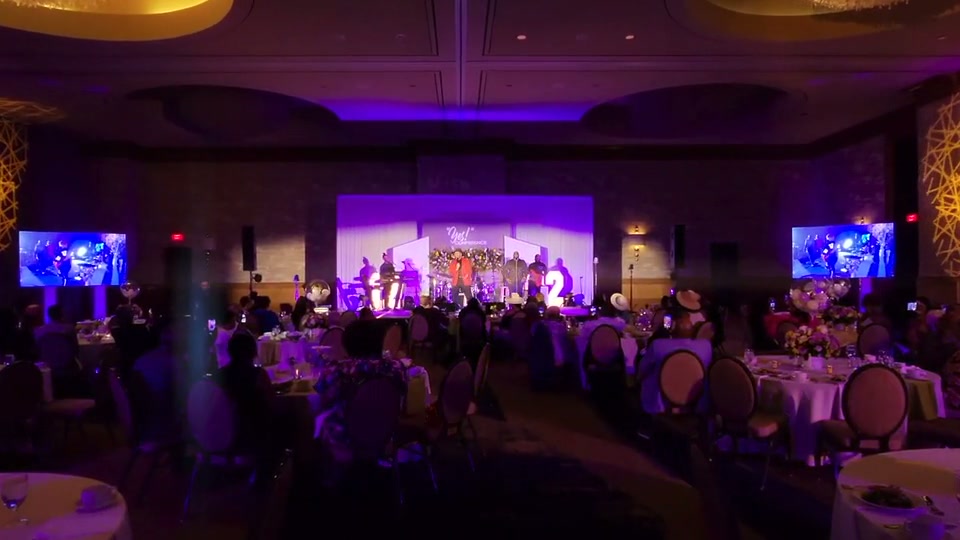 Guests laughing at a reception lit with saturated red lighting